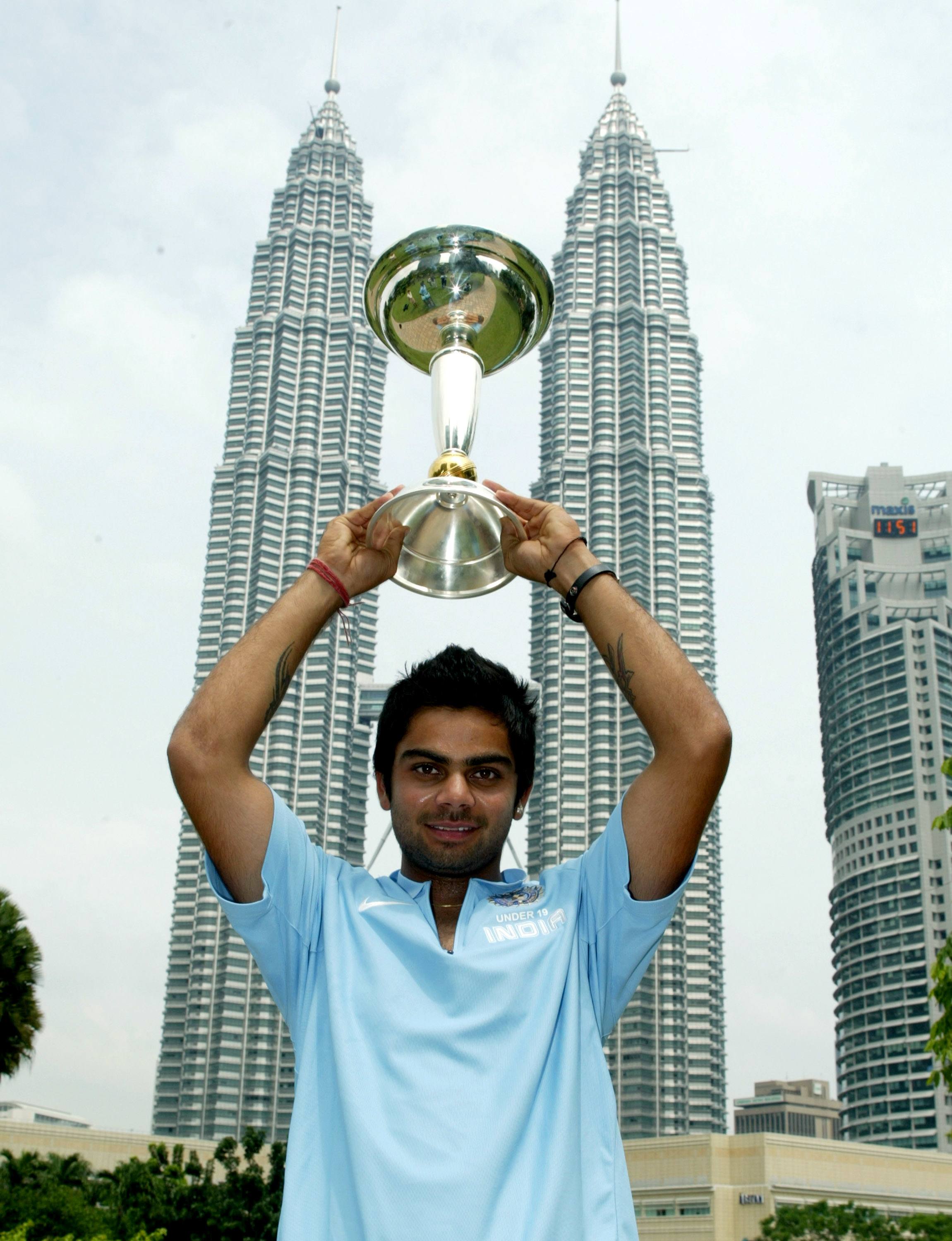 India U19 captain Virat Kohli proudly holding the ICC U/19 Cricket World Cup trophy high above his head with Petronas Twin Towers towering behind him in Kuala Lumpur, March 3, 2008