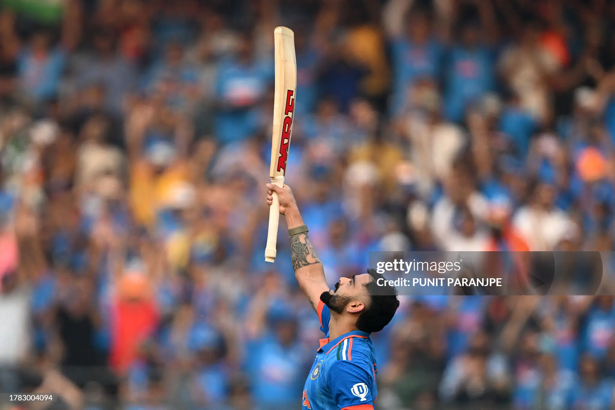 Virat Kohli bowing to Sachin Tendulkar with bat raised after scoring historic 50th ODI century at Wankhede Stadium